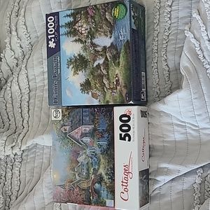Two unopened puzzles with cottages and scenery